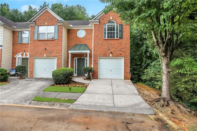 a front view of a house with a yard and potted plants