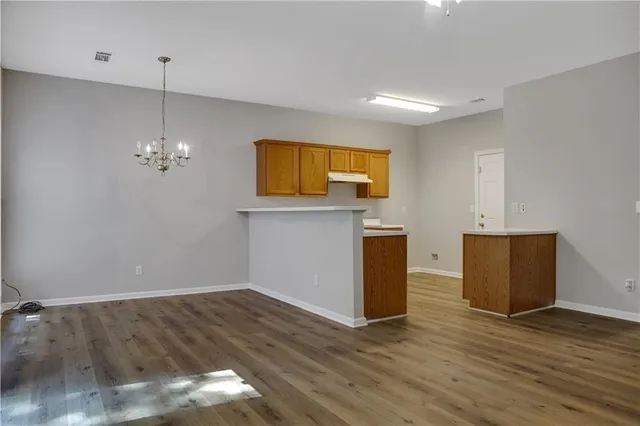 a view of a kitchen with wooden floor and a ceiling fan
