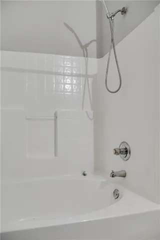 a bathroom with a bath tub with a shower