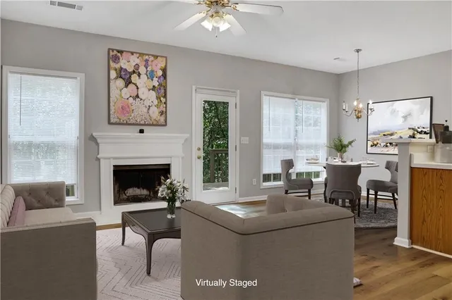 a living room with furniture a fireplace and a large window