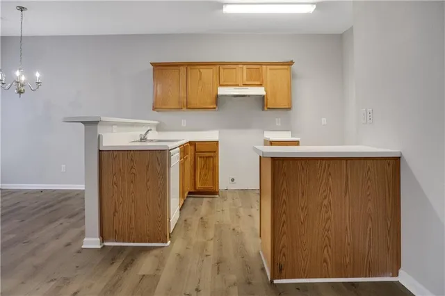 a view of a kitchen with a sink and wooden floor