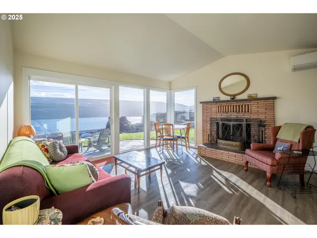 a living room with furniture a fireplace and a floor to ceiling window