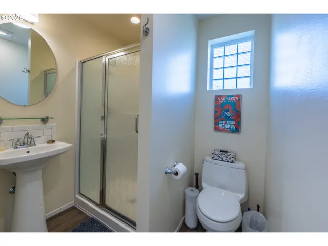 a bathroom with a sink a toilet and shower