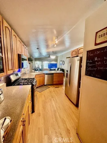 a view of a kitchen with refrigerator and wooden floor