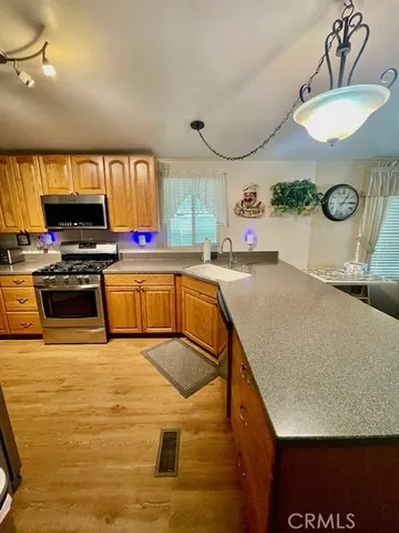a kitchen with kitchen island a stove and a sink