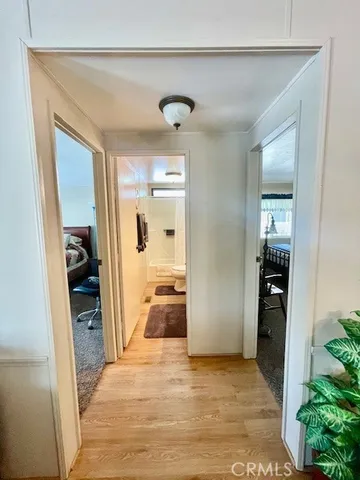 a view of a hallway view with wooden floor and living room