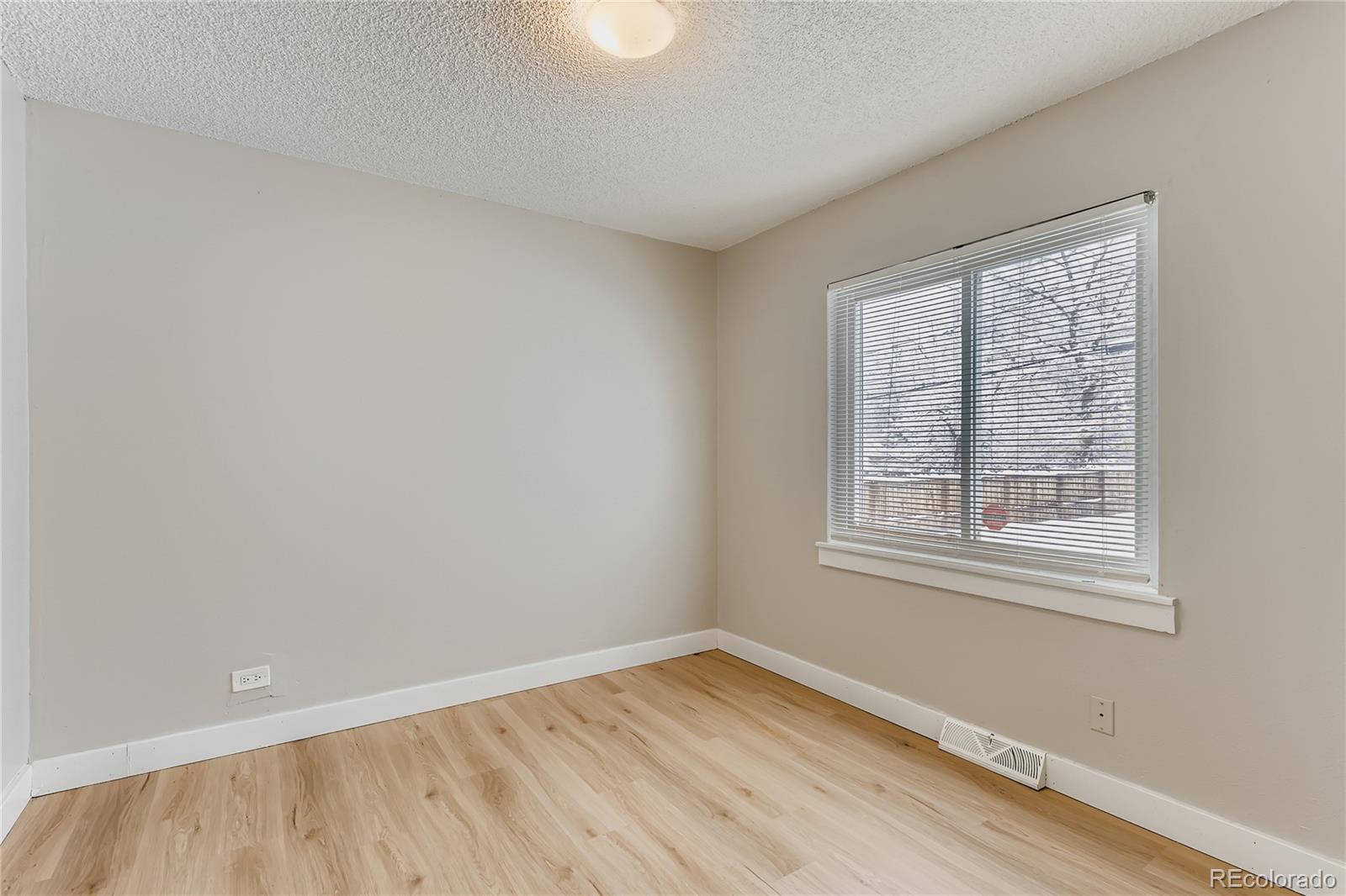 700 Perry Street Denver, CO 80204 - Photo 12 of 16 an empty room with wooden floor and windows