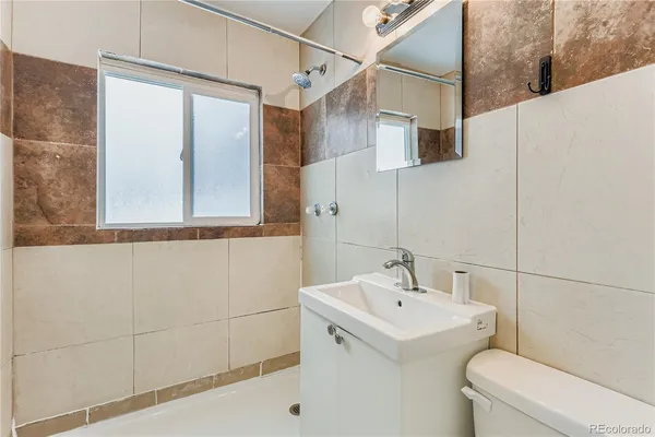 a bathroom with a sink a toilet and a mirror