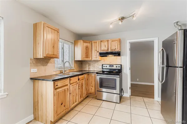 a kitchen with stainless steel appliances granite countertop a stove a refrigerator and a sink