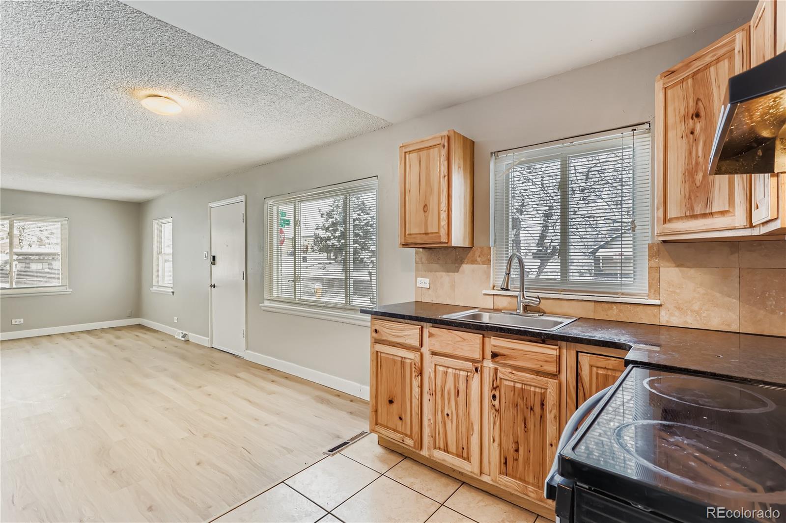 700 Perry Street Denver, CO 80204 - Photo 5 of 16 a view of a kitchen with granite countertop lots of white stainless steel appliances cabinets and a window
