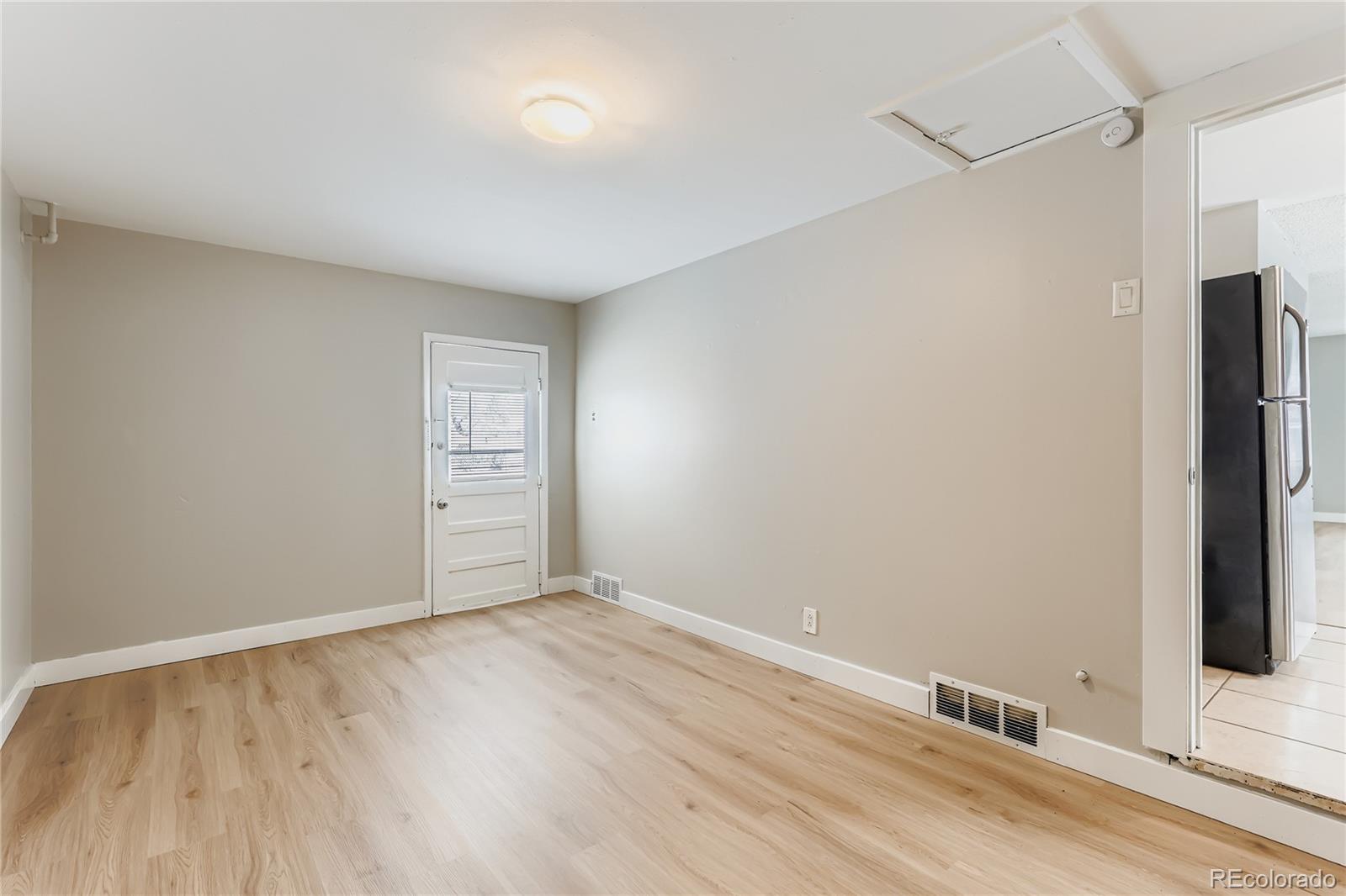 700 Perry Street Denver, CO 80204 - Photo 8 of 16 a view of an empty room with wooden floor and a window