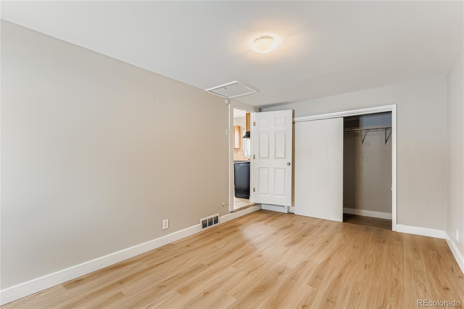 700 Perry Street Denver, CO 80204 - Photo 9 of 16 an empty room with wooden floor and windows