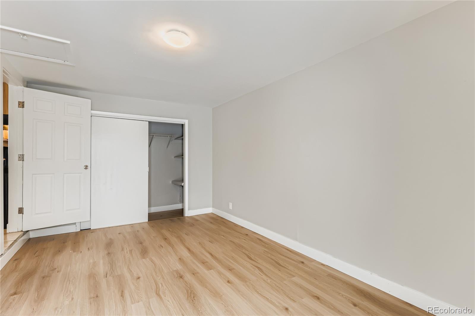 700 Perry Street Denver, CO 80204 - Photo 10 of 16 a view of an empty room with wooden floor and a window