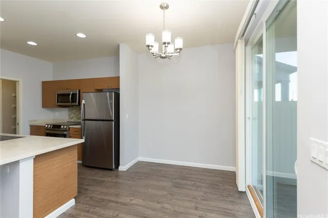 a kitchen with stainless steel appliances granite countertop a refrigerator a sink dishwasher a stove and a dining table with wooden floor