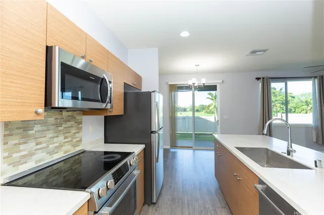 a kitchen with granite countertop stainless steel appliances a sink stove and microwave
