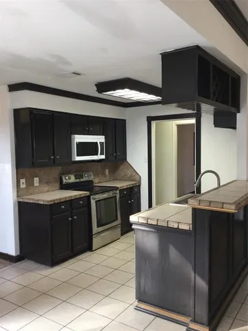 a kitchen with stainless steel appliances granite countertop a sink and a stove