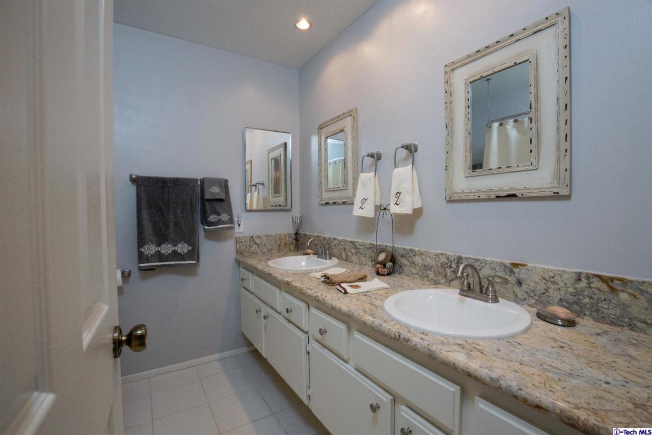 25633 Salceda Road Valencia, CA 91355 - Photo 19 of 29 a bathroom with a granite countertop sink and a mirror