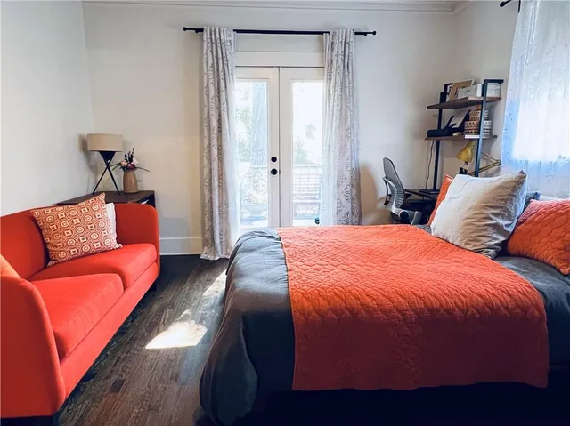 a bedroom with bed couch and window