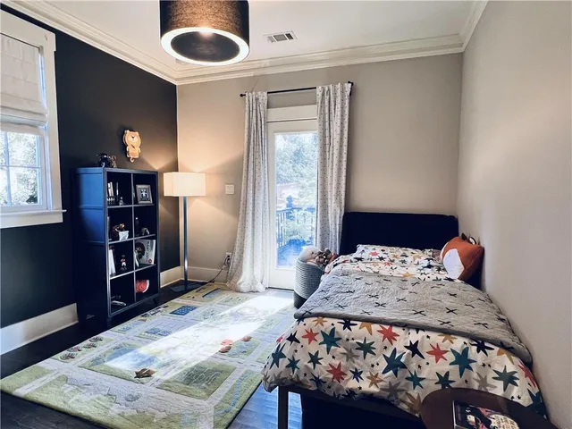 a bedroom with a bed and a dresser with wooden floor