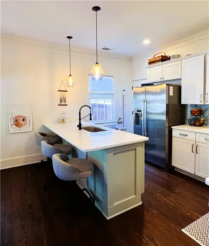 a kitchen with a sink a counter space appliances and cabinets