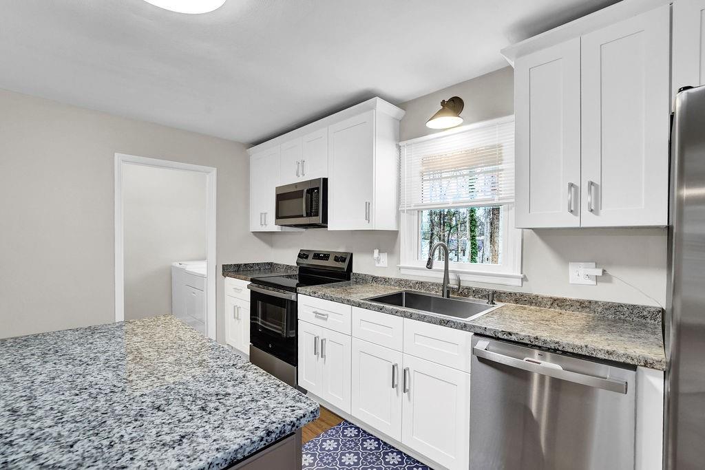 3091 Clifton Road Southeast Smyrna, GA 30080 - Photo 15 of 36 a kitchen with granite countertop a sink stainless steel appliances and white cabinets