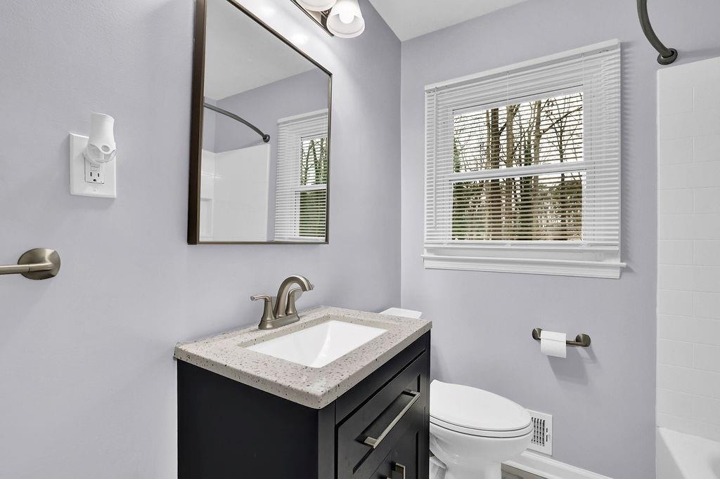 3091 Clifton Road Southeast Smyrna, GA 30080 - Photo 21 of 36 a bathroom with a toilet a sink a mirror and a window