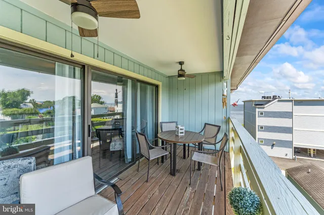 a balcony with wooden floor and outdoor seating