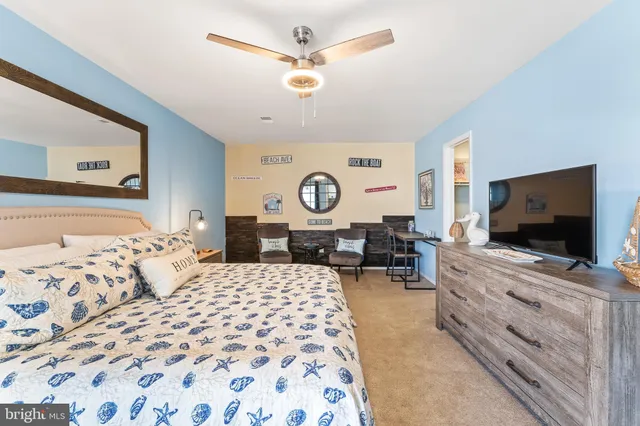 a bedroom with a large bed and a flat tv screen