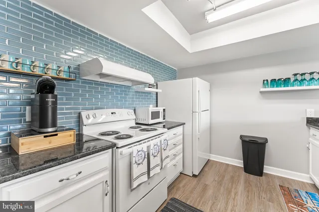 a kitchen with stainless steel appliances granite countertop a sink stove and wooden floor