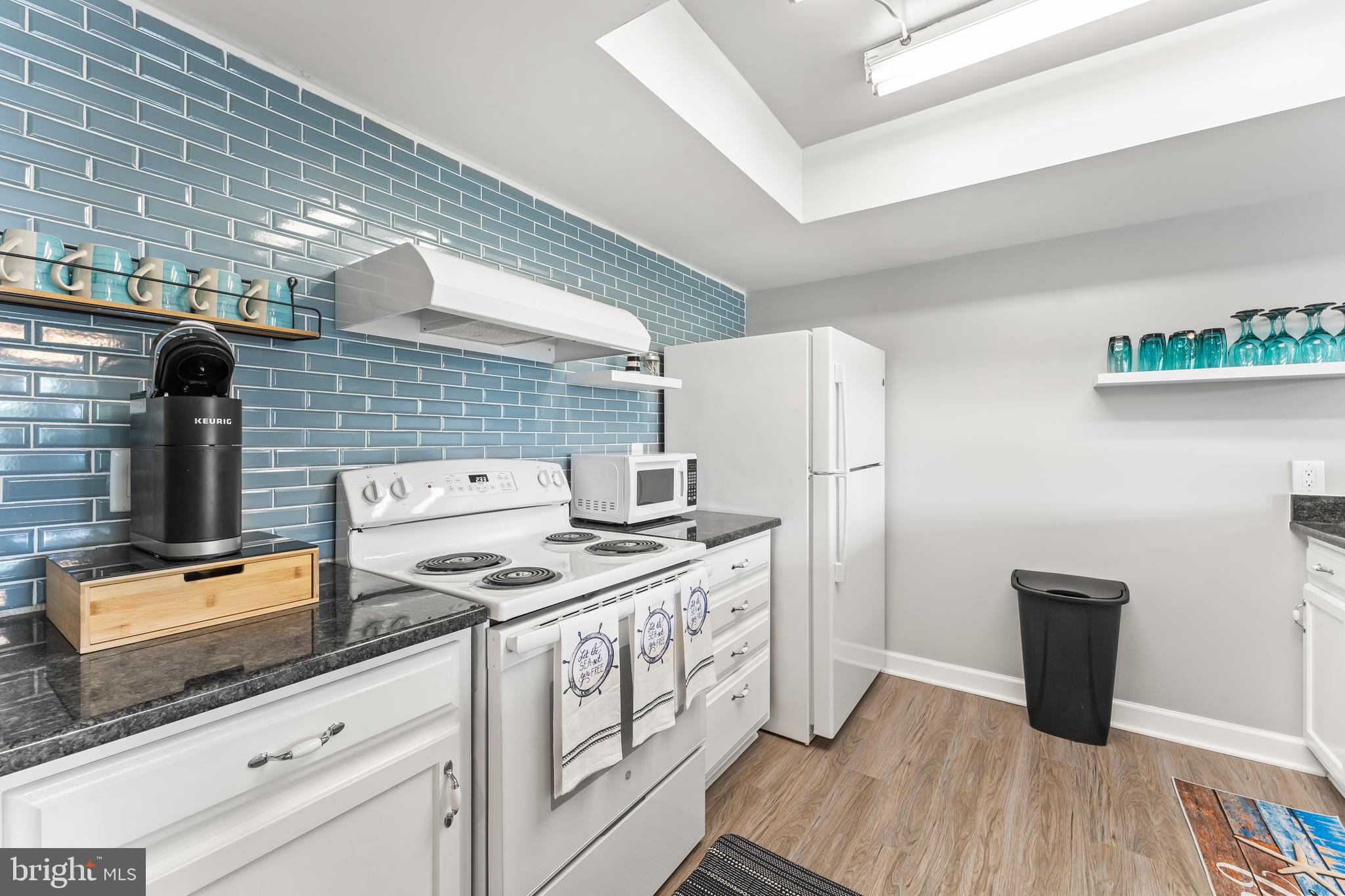 715 Washington Colonial Beach, Unit 15 Colonial Beach, VA 22443 - Photo 5 of 42 a kitchen with granite countertop a stove and a refrigerator