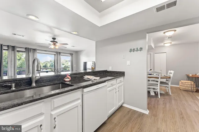 a kitchen with granite countertop a sink and cabinets