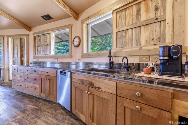 a room with stainless steel appliances a dining table and chairs
