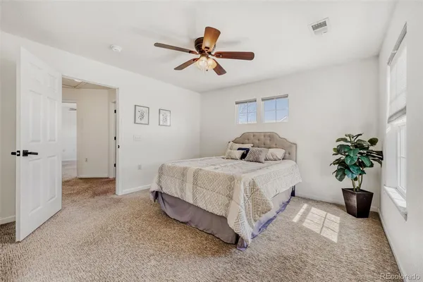a bedroom with a bed and a potted plant