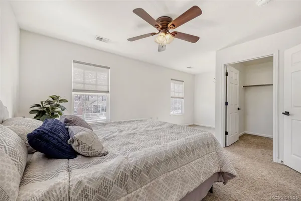 a bedroom with a bed and a ceiling fan