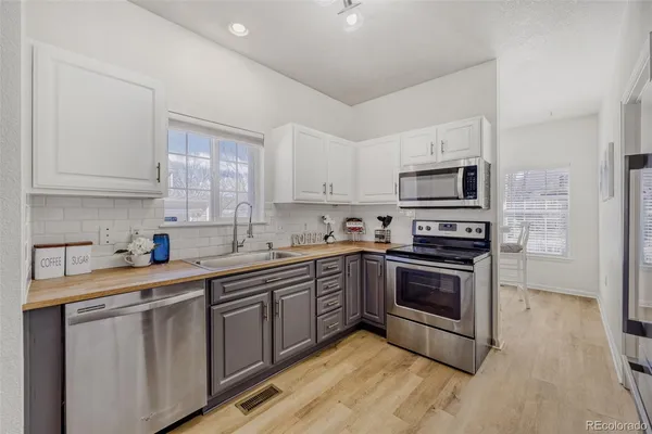 a kitchen with stainless steel appliances granite countertop a stove a sink dishwasher and a microwave oven with wooden floor