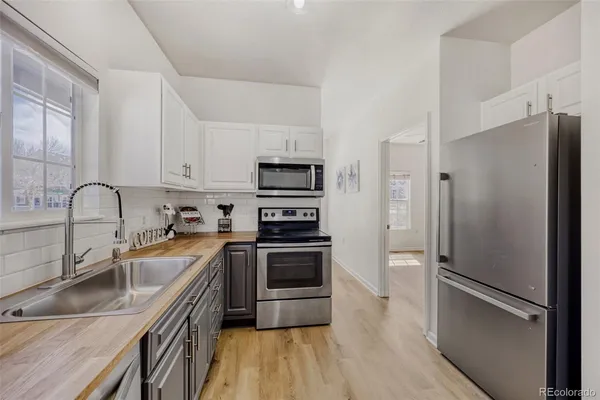 a kitchen with stainless steel appliances a refrigerator sink and microwave