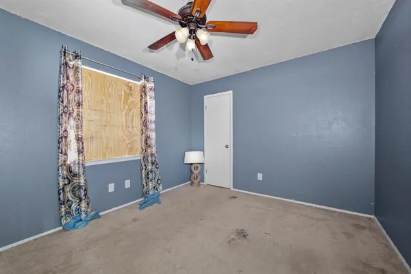 an empty room with closet and fan