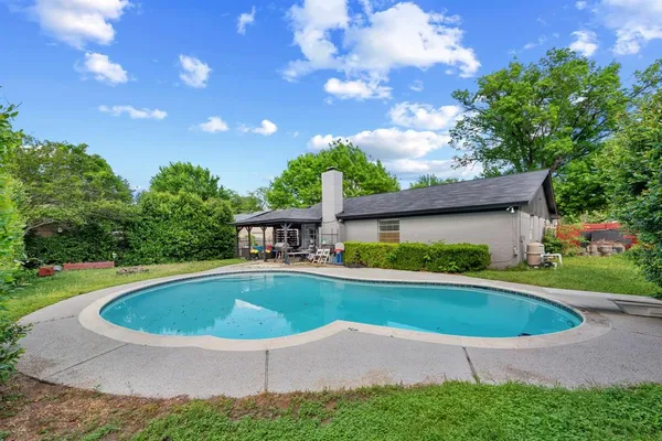 a view of pool with a yard