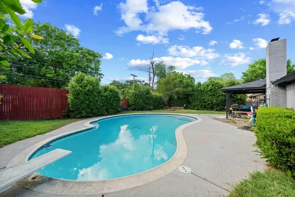 a view of a swimming pool with a patio and a yard