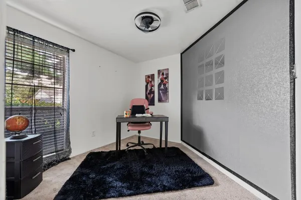 a view of a workspace with furniture and a window