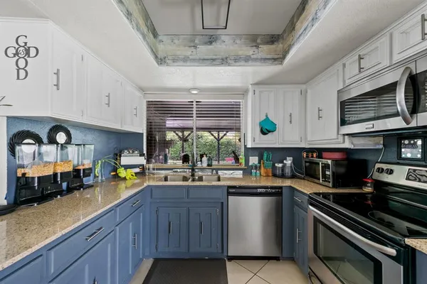 a kitchen with stainless steel appliances a sink a stove and cabinets
