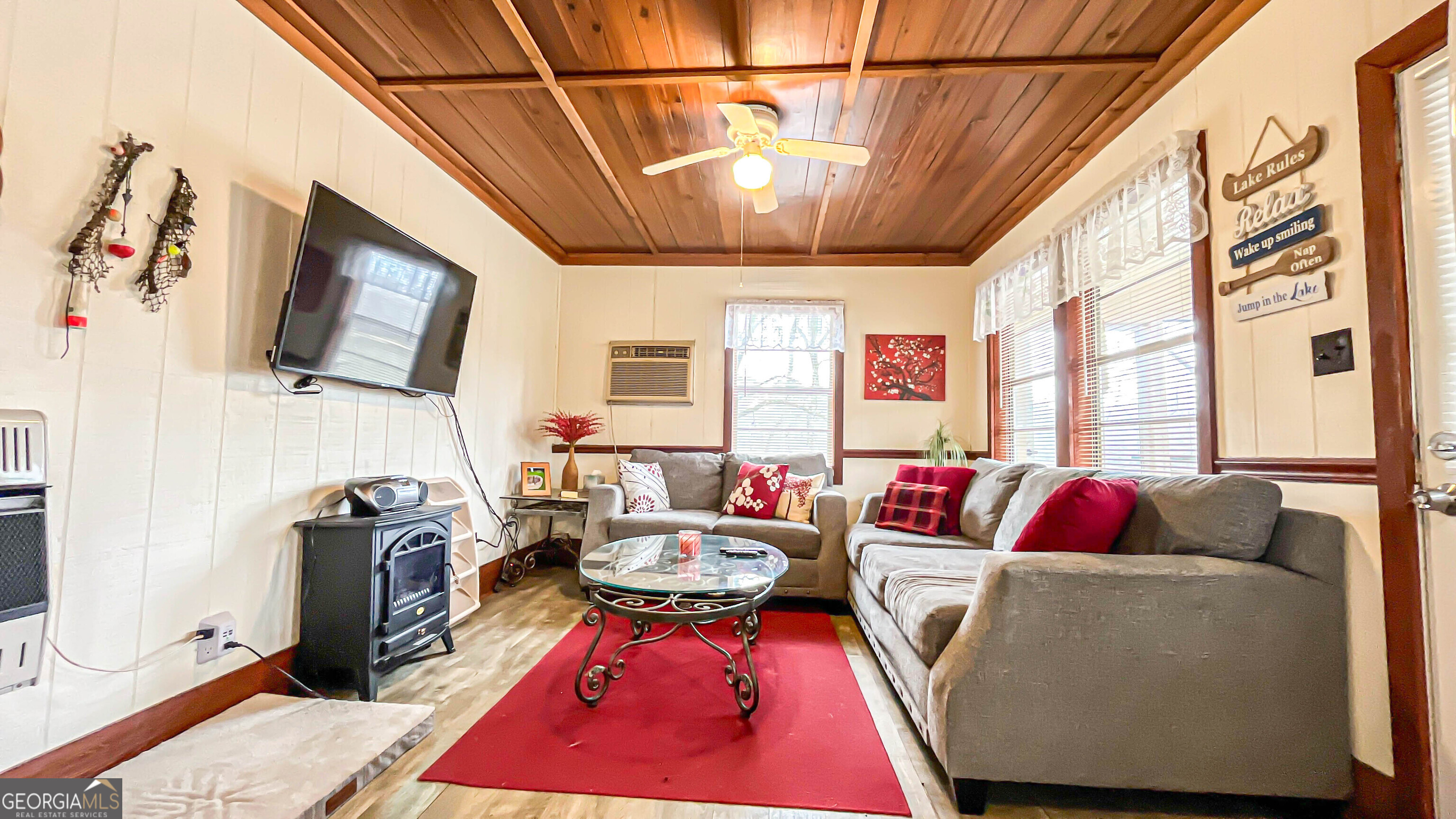 242 Katy Lake Road Jackson, GA 30233 - Photo 14 of 113 a living room with furniture a flat screen tv and a floor to ceiling window