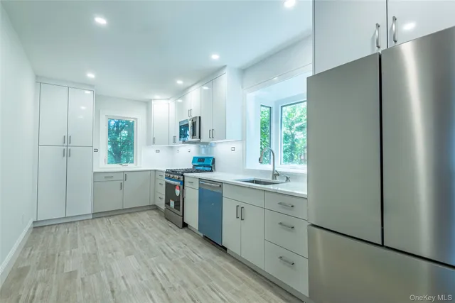 a kitchen with a white cabinets and wooden floor