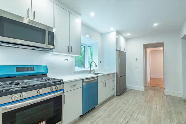 a kitchen with stainless steel appliances a stove a sink and a microwave