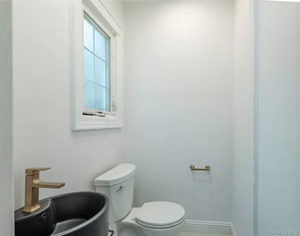 a white toilet sitting next to a bathroom sink and vanity