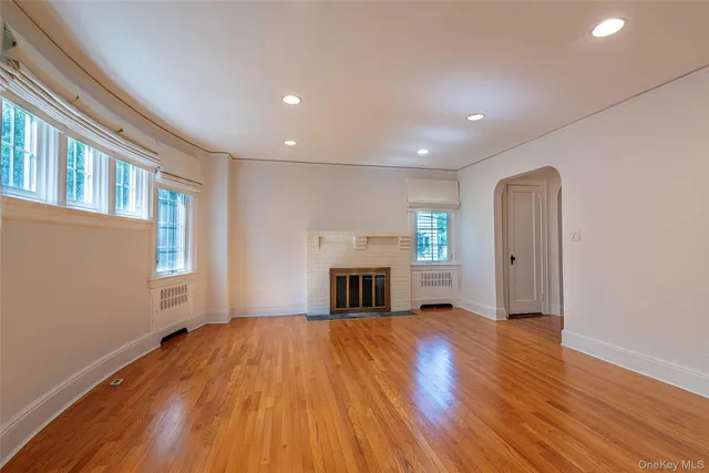 wooden floor fireplace and windows in an empty room