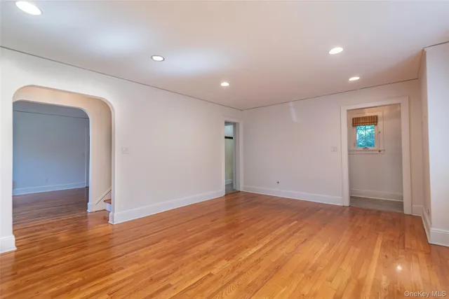an empty room with wooden floor and entrance
