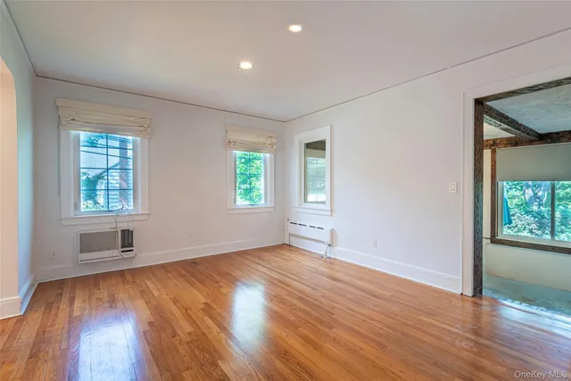 an empty room with wooden floor and a window