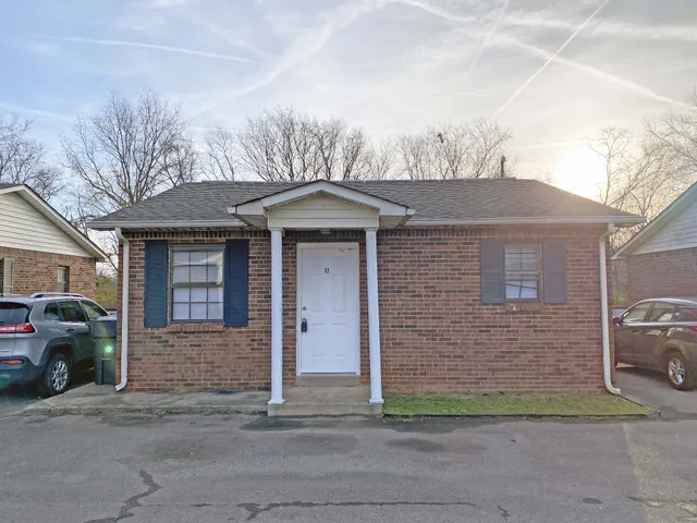 a front view of a house with a garden and garage