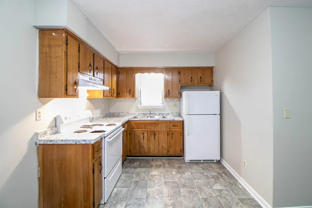 a kitchen with a refrigerator a stove top oven a sink and dishwasher